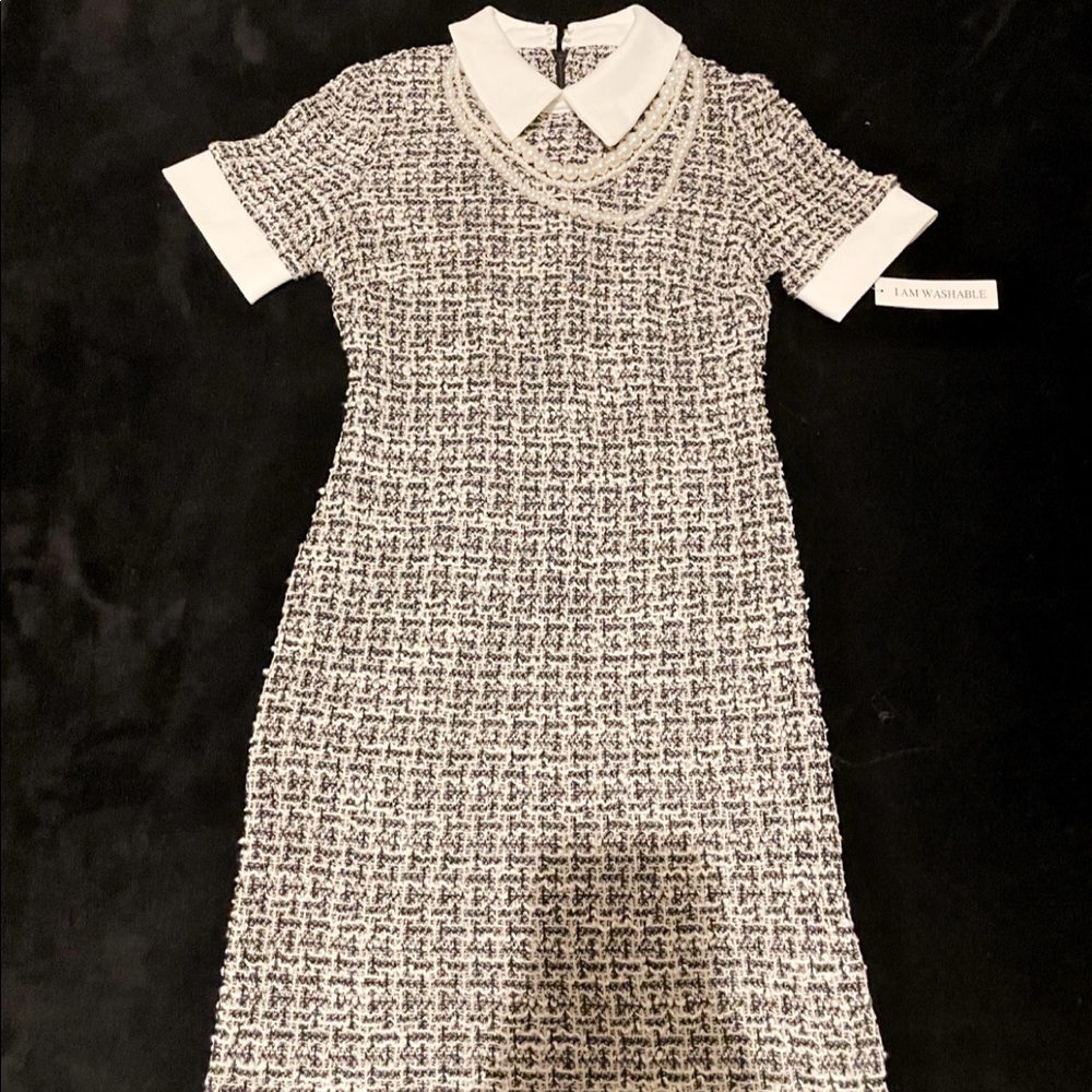 Knee length black and white dress with pearl necklace accessory